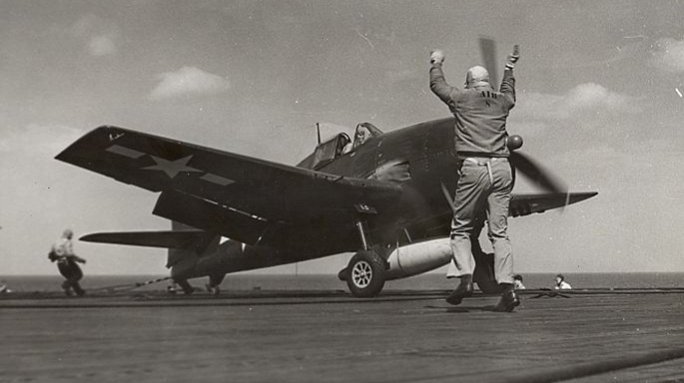 Deck crew guide a Hellcat to takeoff. Gift in memory of John Valdemor Peterson.